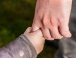 picture of an adult holding a child's hand to illustrate autism treatment