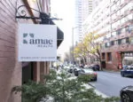 Amae health sign on brick building looking down an alleyway