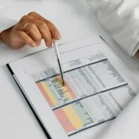 Hands of Doctor Holding Notepad, Medical Data and Pen
