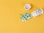 Mixed pill and bottle on a pastel orange background Photo by Etactics Inc on Unsplash