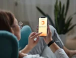 Over the shoulder view of a woman using Sword Health's new Mind mental health app on a smartphone.