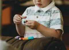 Autism therapy child playing with colored blocks Photo by Caleb Woods on Unsplash